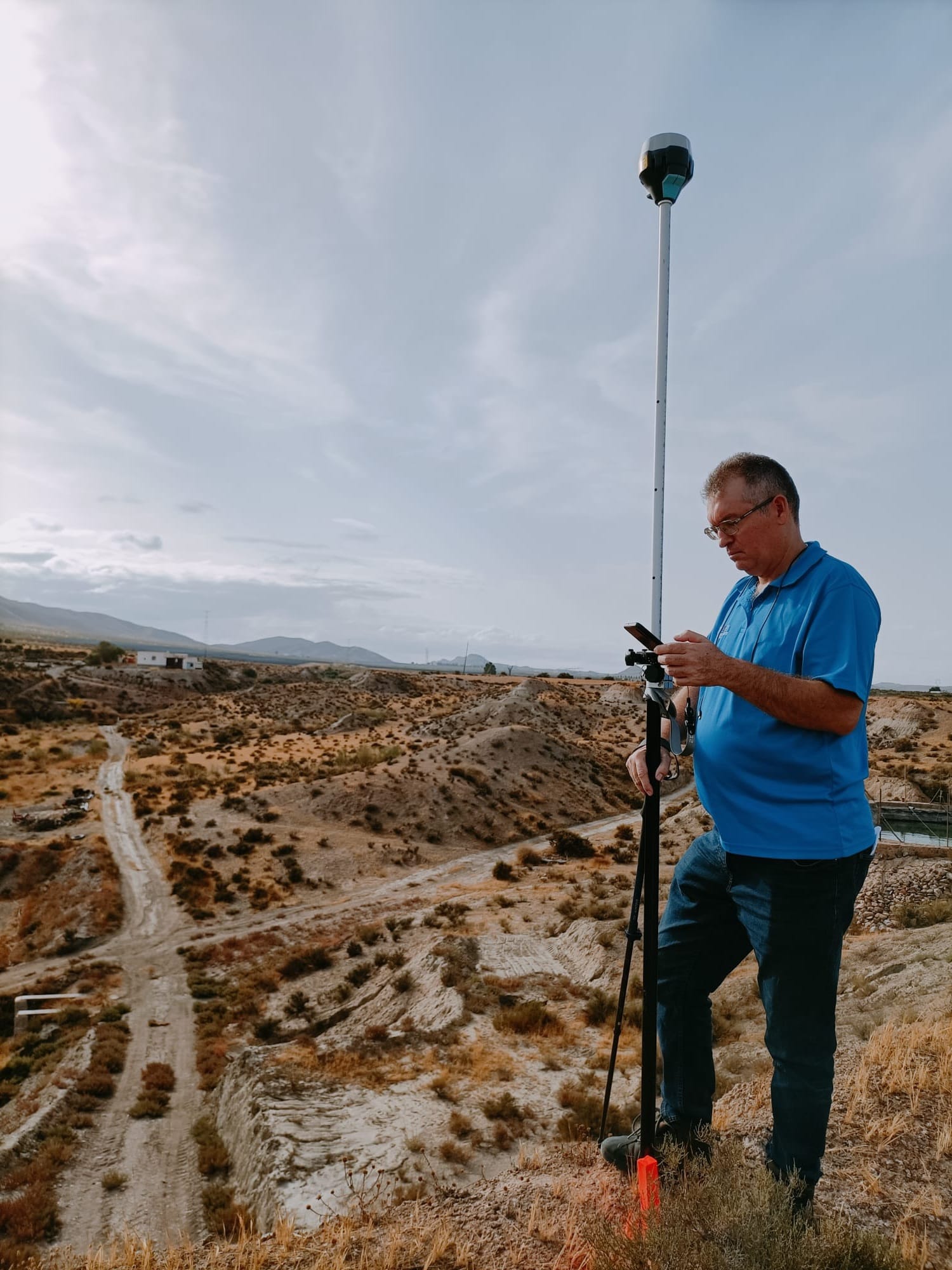 Topógrafo realizando levantamiento GNSS RTK en campo abierto, Almería